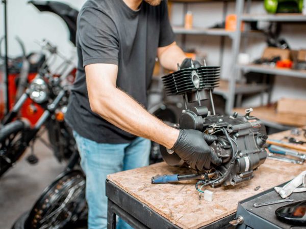 man-repairing-motorcycle-engine-resize.jpg man-repairing-motorcycle-engine-resize.jpg